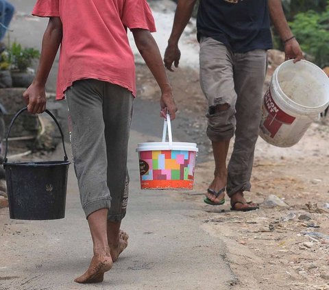 FOTO: Antusiasme Warga Pinggiran Kali Ciliwung Serbu Bantuan Air Bersih