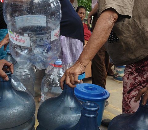 FOTO: Antusiasme Warga Pinggiran Kali Ciliwung Serbu Bantuan Air Bersih