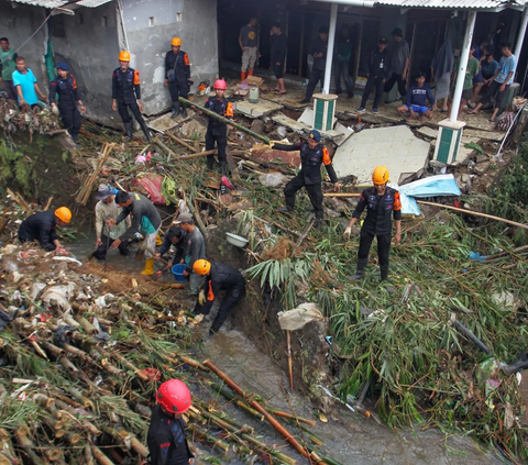 Hujan deras yang turun semalaman di wiayah Bogor membuat Tim SAR gabungan dari Brimob Kedung Halang dan relawan sibuk membersihkan material longsor yang terjadi akibat luapan Kali Cibuluh di Kedung Halang, Bogor, Kamis (30/11/2023).