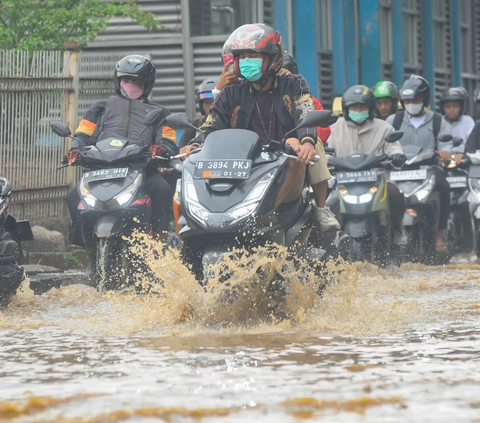 FOTO: Luapan Air Kali Baru di Depan Pasar Induk Kramat Jati Banjiri Jalan Raya Bogor, Lalu Lintas Macet Parah