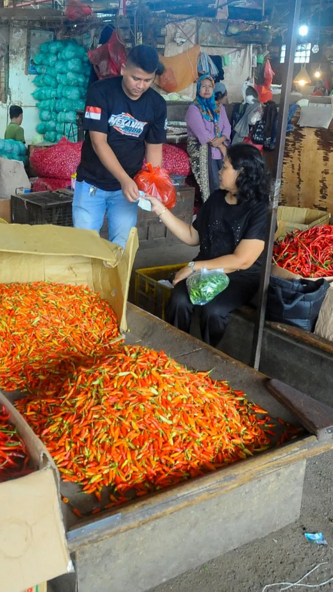 Pedagang melakukan transaksi dengan pembeli saat harga cabai rawit merah masih tinggi di Pasar Induk Kramat Jati, Jakarta, Kamis (30/11/2023).