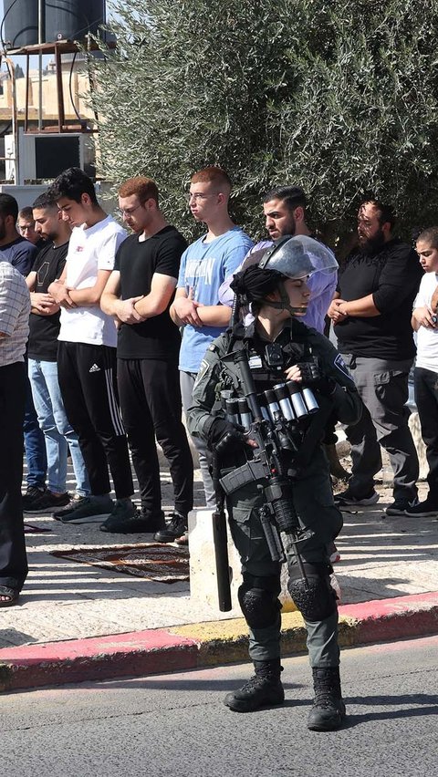 Mereka tetap khusyuk melaksanakan salat Jumat di trotoar di luar lingkungan Masjid Al Aqsa.