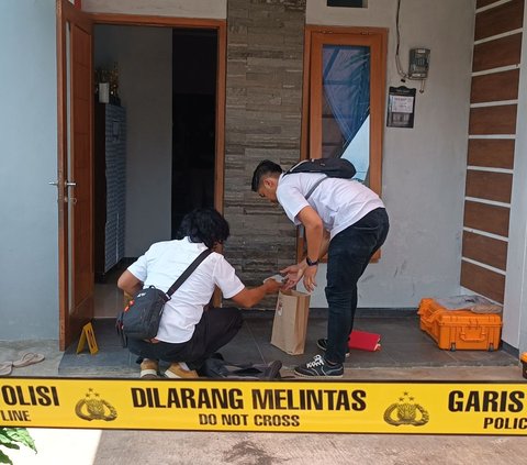 Polisi melakukan olah TKP di rumah keluarga yang diduga bunuh diri bersama.