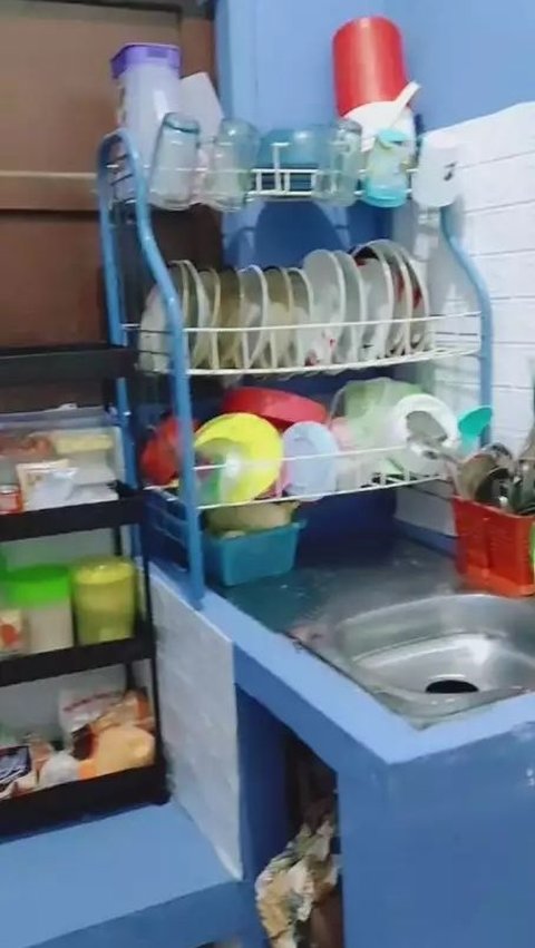 The kitchen wallpaper was changed and the glasses and plates were neatly arranged inside the cupboard.