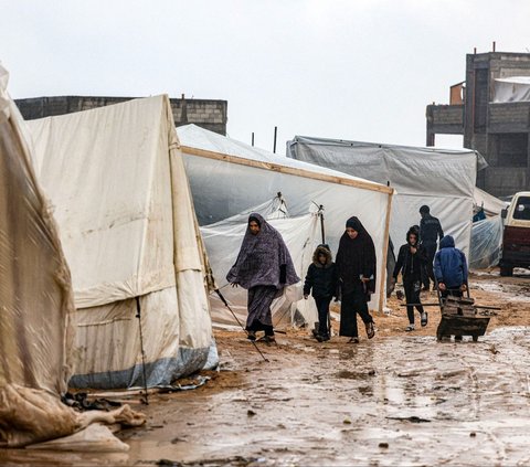 FOTO: Potret Menyayat Hati Pria Palestina Gendong Jenazah Anak Korban Serangan Israel di Tengah Banjir dan Hujan Deras