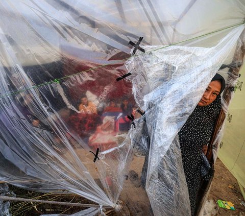 FOTO: Potret Menyayat Hati Pria Palestina Gendong Jenazah Anak Korban Serangan Israel di Tengah Banjir dan Hujan Deras