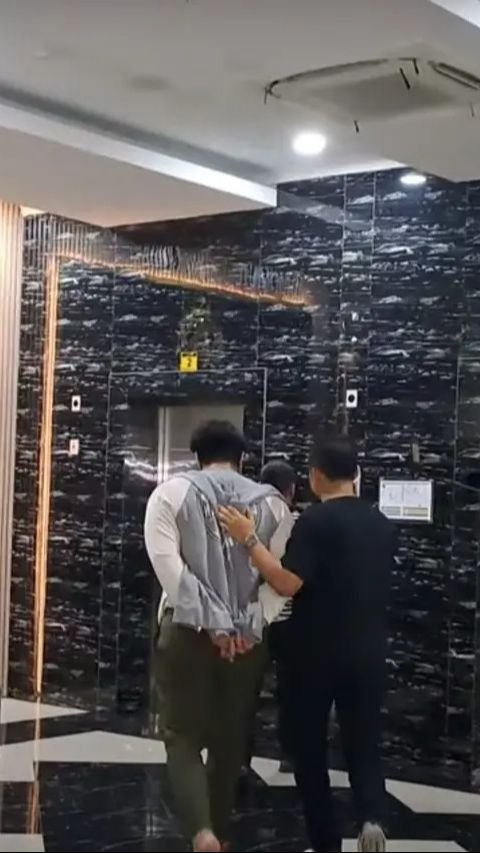 Ia kemudian dibawa masuk ke lift untuk menjalani proses hukum selanjutnya.
