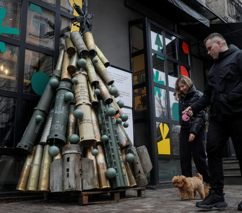 Menjelang Hari Natal ada pemandangan unik yang menarik perhatian para pejalan kaki di trotoar jalan di pusat Kota Kyiv, Ukraina.<br><br>Pemandangan unik itu adalah pohon Natal yang dibuat dengan bahan-bahan bekas pertempuran.