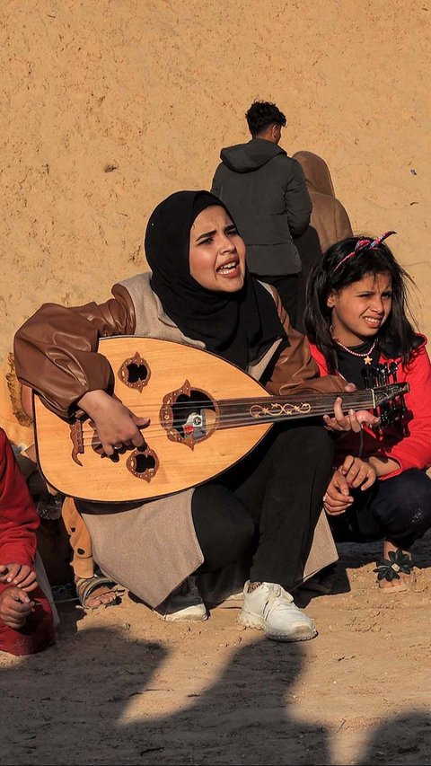 Hassouna mengajak anak-anak Jalur Gaza untuk bernyanyi bersama dengan iringan musik Oud atau kecapi oriental.