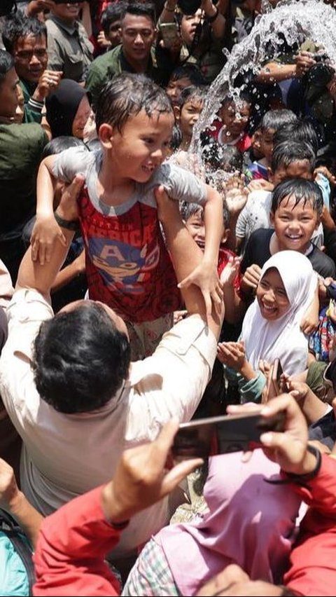 Portrait of Prabowo Subianto Playing Water with Children After Inaugurating a Water Source in Kuningan