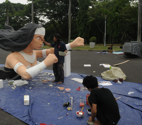 Pekerja seni sedang  menyelesaikan pembuatan patung untuk mobil hias jelang acara Jakarnaval untuk malam Tahun Baru 2024 di Silang Monas, Jakarta, Selasa (26/12/2023).