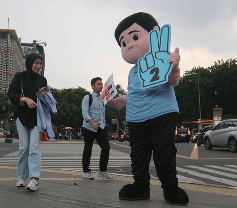 Relawan berkostum boneka Prabowo Subianto melakukan kampanye di perempatan kawasan Sarinah, Jalan Jenderal MH Thamrin, Jakarta, Jumat (29/12/2023). Dalam kampanyenya, relawan Prabowo dan Gibran ini tampak menyapa warga sembari membagikan susu gratis.