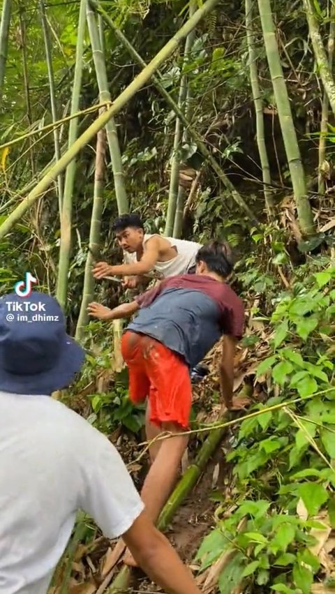 Panik melihat salah satu temannya terjebak di sungai, mereka pun menebang sebatang bambu sebagai alat bantu menyelamatkan temannya.