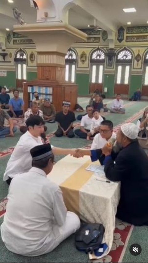 Young Gwang says the shahada guided by an ustadz. He wears a white shirt and black pants. He also appears fluent in Indonesian language.