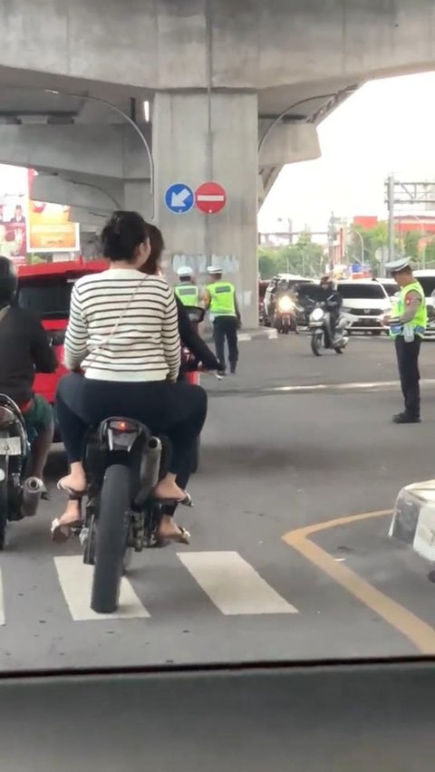 Polisi Sibuk Main HP, Dua Wanita Pengendara Motor Tanpa Helm Ini Lolos dari Tilang<br>