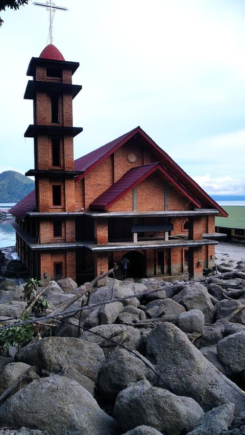 Sejumlah batu-batu besar yang terbawa tanah longsor berada di depan sebuah gereja di Humbang Hasundutan, Sumatera Utara, pada 2 Desember 2023. Twitter/@BNPB_Indonesia