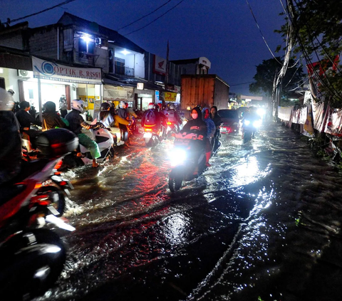 Para pengendara bermotor terpaksa memperlambat laju kendaraannya saat melewati genangan banjir yang merendam kawasan Jalan Dr. Setiabudi, Pamulang, Tangerang Selatan, Rabu (06/12/2023).
