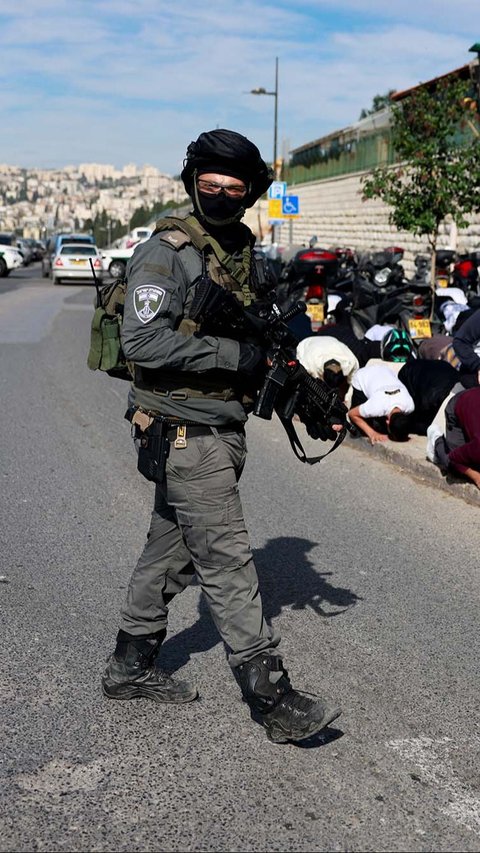 Sepanjang warga Palestina khusyuk melaksanakan salat Jumat, para polisi Israel yang ditugaskan tampak terus mondar-mandir melakukan pengawasan. REUTERS/Ammar Awad