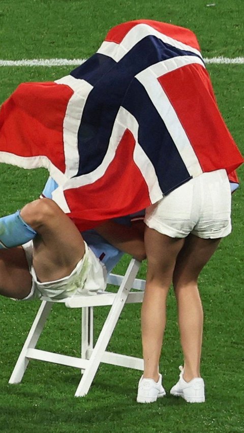 Di tengah lapangan bola itu, Erling Haaland yang duduk dikursi terlihat menutup diri bersama kekasihnya dengan bendera Norwegia. Entah apa yang dilakukan kekasihnya kepada Erling Braut Haaland.