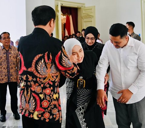 Putri Ariani memenuhi undangan Jokowi bersama kedua orang tuanya. Dia tampil anggun dengan baju hitam dan jilbab putih.