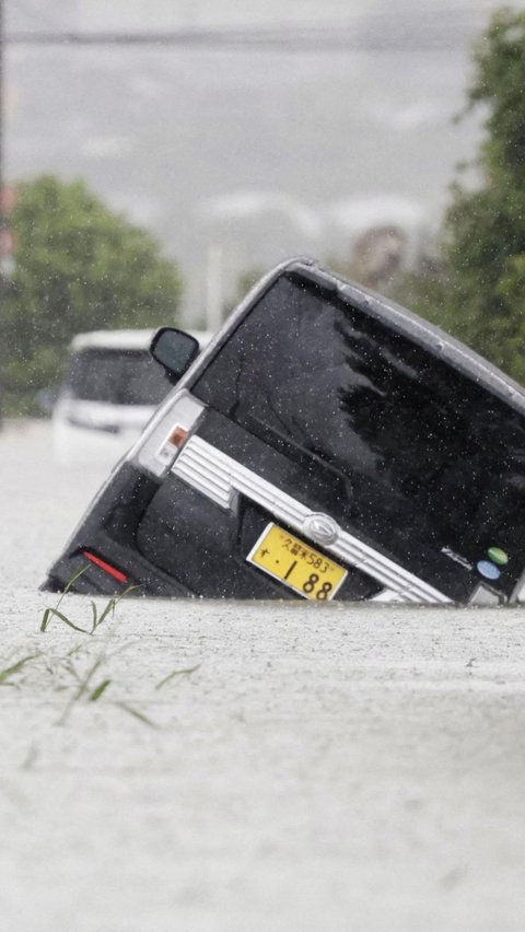 Genangan banjir yang tinggi dan merata juga membuat pengendara roda empat kesulitan mencari jalur yang tepat sehingga mengakibatkan beberapa mobil terperosok ke dalam lubang di Kurume, Prefektur Fukuoka, Jepang.