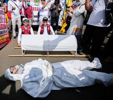 Salah satu yang menarik perhatian adalah aksi teatrikal tenaga medis. Mereka membawa kurung batang hingga tampil memakai kostum APD saat teatrikal.