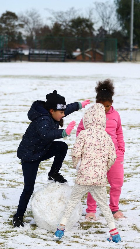 Turunnya salju di Johannesburg ini membuat anak-anak bersemangat membuat bola-bola salju dan mencoba menangkap serpihan salju dengan tangan mereka.
