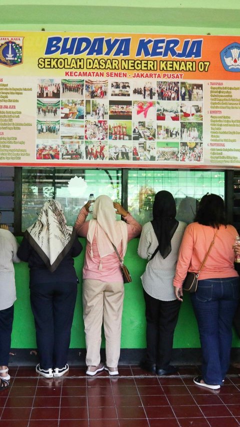 Sejumlah orang tua menunggu anak-anaknya saat sedang menjalani Masa Pengenalan Lingkungan Sekolah (MPLS) di hari pertama di halaman SDN Kenari 07 dan 08  di kawasan Salemba, Jakarta, Rabu (12/7/2023).