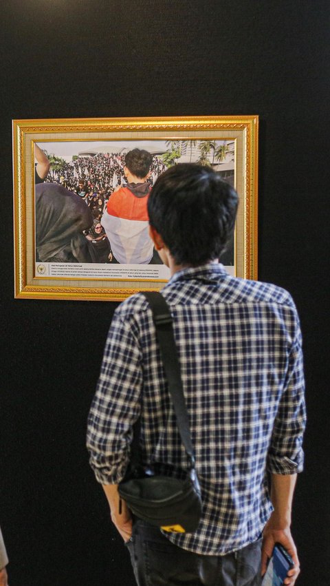 Seorang pengunjung mengamati salah satu karya fotografi dalam pameran Foto Parlemen Warna Warni ke XIII/2023 di Gedung Nusantara II, Jakarta, Rabu (12/7/2023).