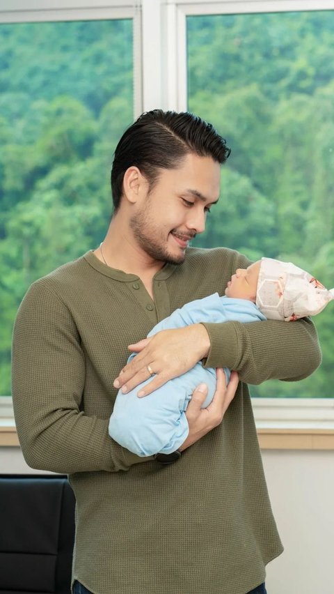 Ini momen Randy Pangalila saat menggendong anak keduanya. Randy terlihat bahagia memandang Asher.