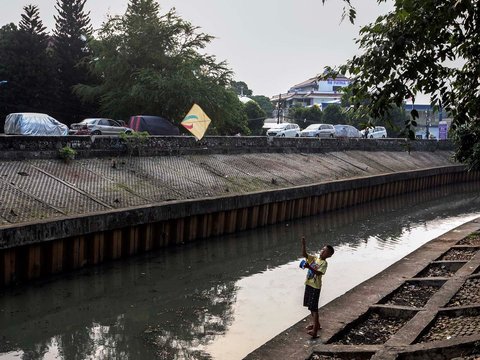 FOTO: Ruang Terbuka Hijau Minim, Anak-Anak di Jakarta Main Layang-Layang di Pinggir Kali