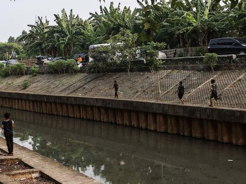 FOTO: Ruang Terbuka Hijau Minim, Anak-Anak di Jakarta Main Layang-Layang di Pinggir Kali