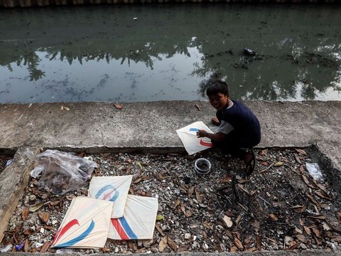 FOTO: Ruang Terbuka Hijau Minim, Anak-Anak di Jakarta Main Layang-Layang di Pinggir Kali