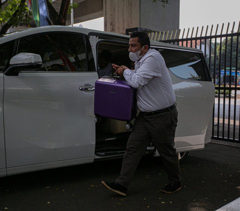 Datang dengan menggunakan mobil putih, Pengacara Komisaris PT Solitech Media Sinergy Irwan Hermawan, Maqdir Ismail yang dibantu tim membawa uang Rp27 miliar ke Kejaksaan Agung (Kejagung).