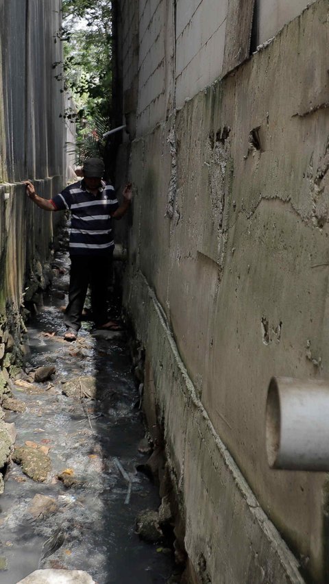 Setiap hari pria berusia 63 tahun itu harus berjalan hati-hati melalui selokan yang basah, lembab dan tidak rata. Akses ini merupakan satu-satu jalan menuju rumahnya di kawasan Jatiwaringin, Bekasi.