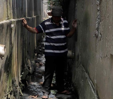 Dua rumah milik Ngadenin dan tetangganya terkepung tembok bangunan setinggi belasan meter yang diduga bakal difungsikan menjadi hotel di Jalan Raya Jatiwaringin, RW. 04, Pondok Gede, Kota Bekasi.