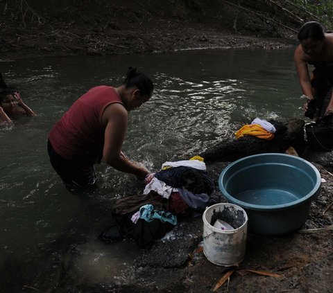 Warga Cibarusah di Kabupaten Bekasi pada Rabu (19/7/2023) terpaksa menggunakan aliran Kali Cihoe  untuk mencuci pakaian dan mandi.