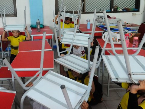 FOTO: Ekspresi Siswa SD di Depok Ikuti Simulasi Gempa, Panik dan Berlindung di Kolong Meja