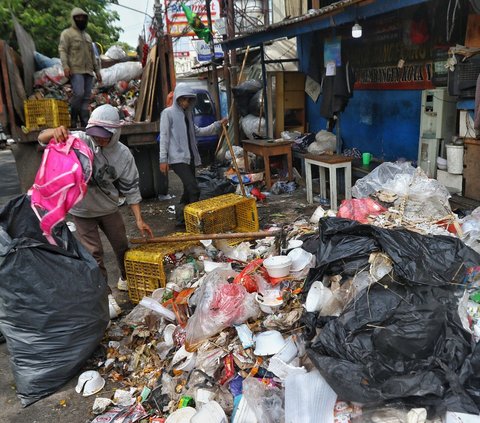 Petugas kebersihan mencari barang-barang di tempat pembuangan sampah sementara di kawasan Petir, Kota Tangerang, Banten, Kamis (20/7/2023).