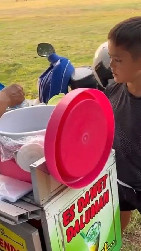 Sering membeli jajanan kaki lima, El tampak percaya diri dan berani memesan langsung minuman es cendol yang ada di sekitar lapangan tersebut.