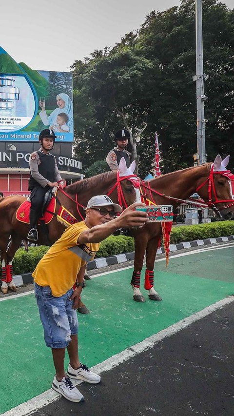 FOTO: Momen Polisi Berkuda Sapa Pengunjung CFD Jakarta, Jadi Ajang Selfie