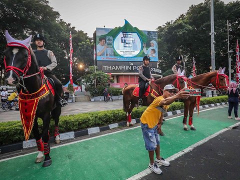 FOTO: Momen Polisi Berkuda Sapa Pengunjung CFD Jakarta, Jadi Ajang Selfie