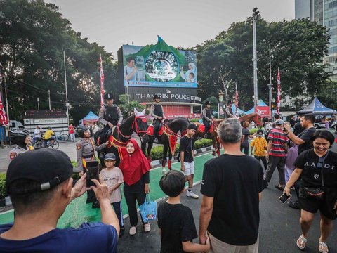 FOTO: Momen Polisi Berkuda Sapa Pengunjung CFD Jakarta, Jadi Ajang Selfie