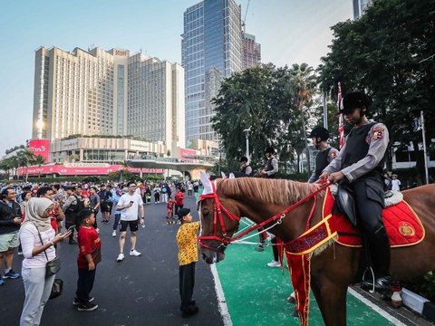 FOTO: Momen Polisi Berkuda Sapa Pengunjung CFD Jakarta, Jadi Ajang Selfie