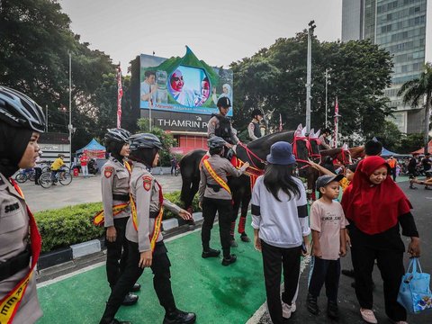 FOTO: Momen Polisi Berkuda Sapa Pengunjung CFD Jakarta, Jadi Ajang Selfie