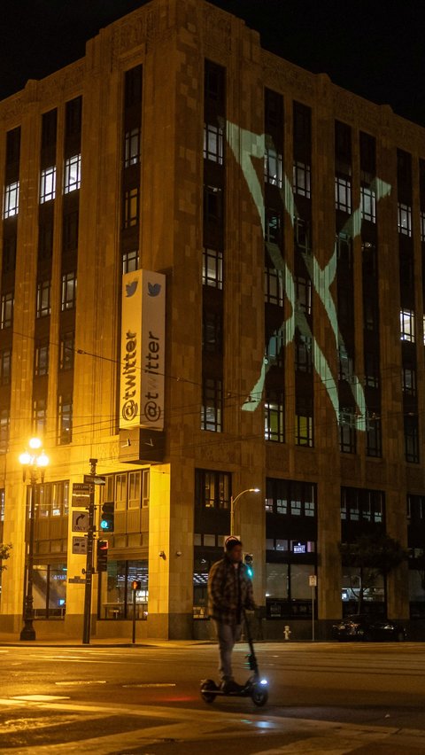 Logo baru Twitter yang berganti menjadi X terlihat diproyeksikan di gedung kantor pusat perusahaan di pusat kota San Francisco, California, AS, pada 23 Juli 2023 malam. <br />( REUTERS/Carlos Barria )