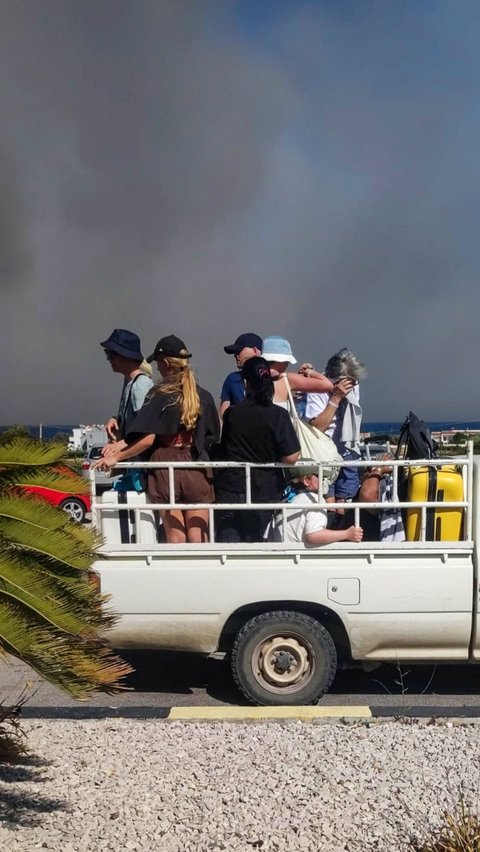 Dalam foto yang diperoleh AFP, beberapa turis tampak ramai-ramai dievakuasi dari sebuah lokasi wisata menggunakan truk .