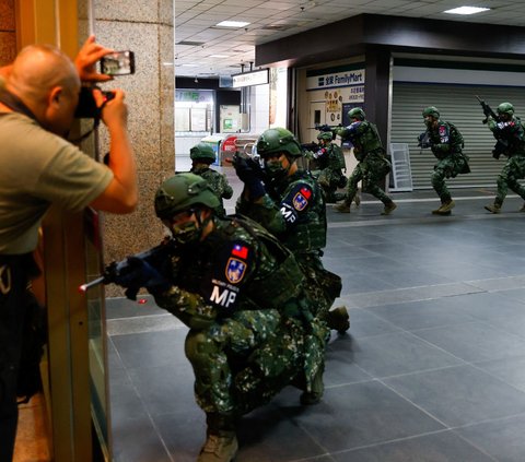 Seorang awak media mengambil foto tentara Taiwan saat melakukan latihan perang di Stasiun Utama Taipei selama latihan militer tahunan di Taipei, Taiwan, Rabu (26/7/2023).