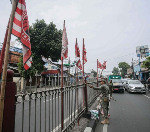Satuan Polisi Pamong Praja ( Satpol PP ) DKI Jakarta terus melakukan penertiban alat peraga partai politik berbentuk bendera yang melanggar aturan di kawasan Jalan Raya Bogor, Jakarta, Rabu (26/7/2023).
