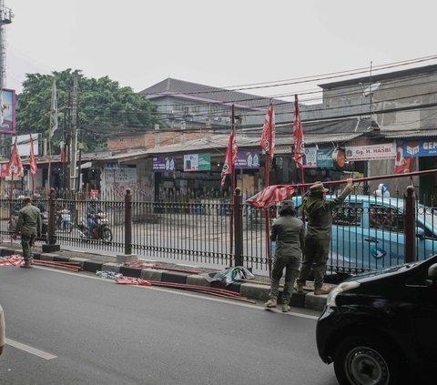 Sejumlah bendera partai politik yang diikat pada pagar pembatas jalan saat ditertibkan oleh<br />petugas Satpol PP di Jalan Raya Jakarta-Bogor.